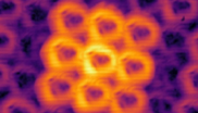 Doughnut-shaped beams of light scatter away from two incredibly small structures with different repeating patterns. (Credit: Wang, et al., 2023, "Optica")